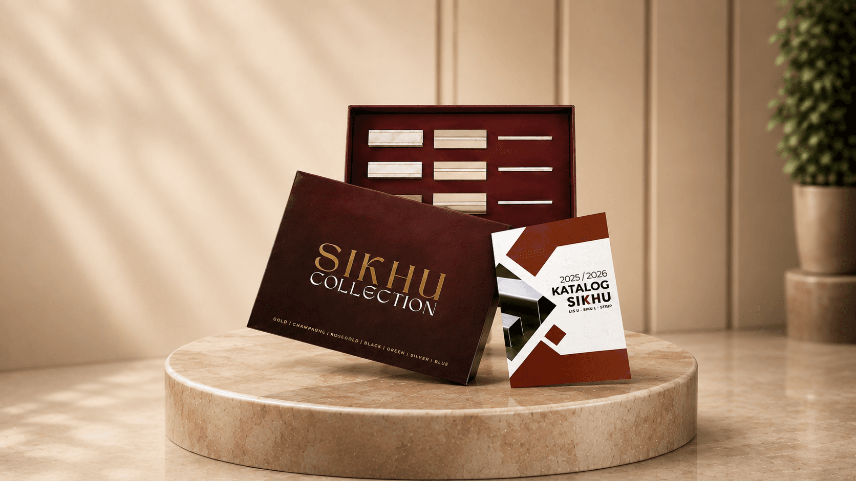 SIKHU Collection Sample Box holding stainless trim offcuts in seven colors, with the 2025/2026 catalog book, on a marble table