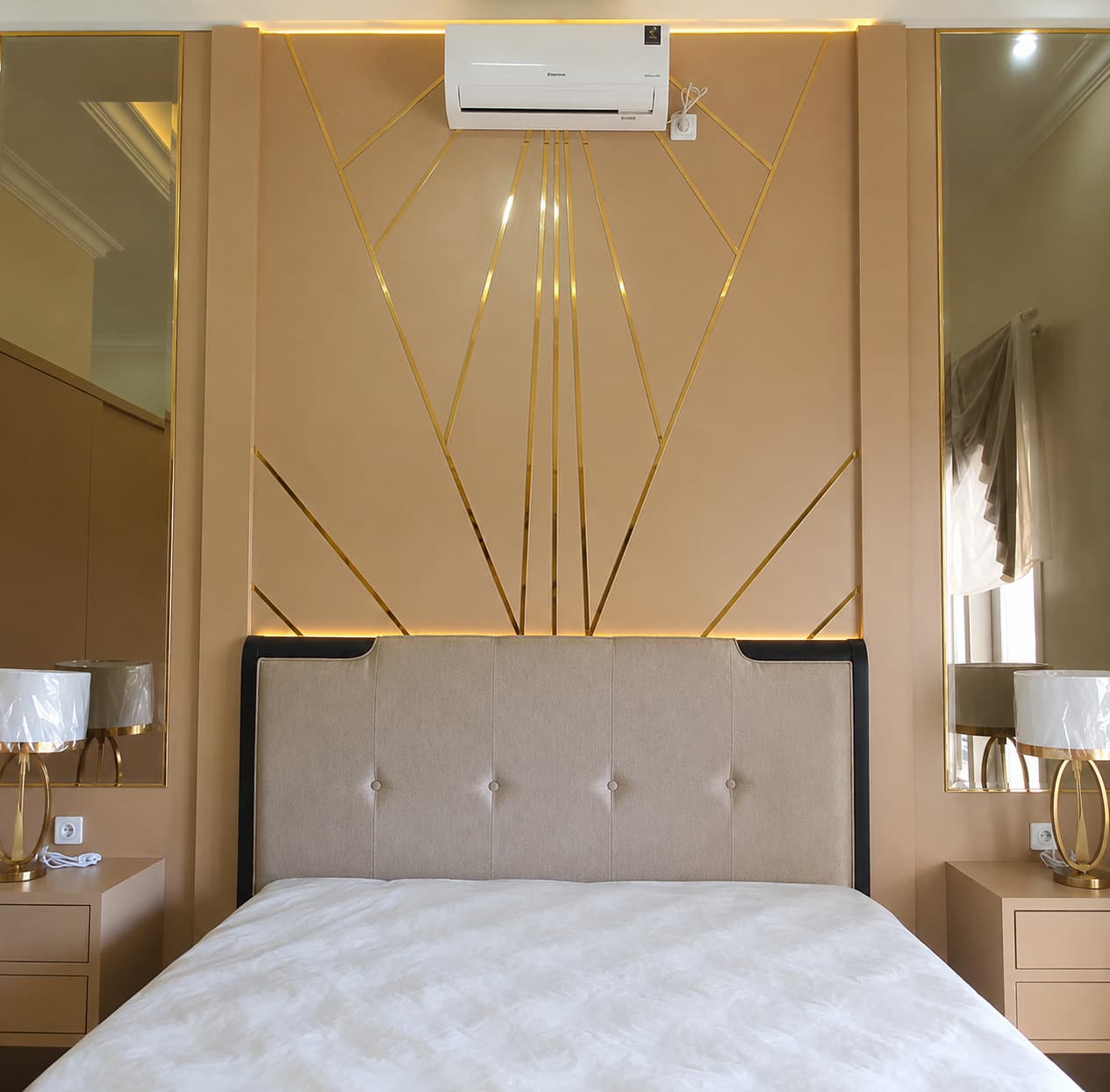 Cream headboard wall with gold trim fanning out like rays, flanked by two gold-framed mirrors